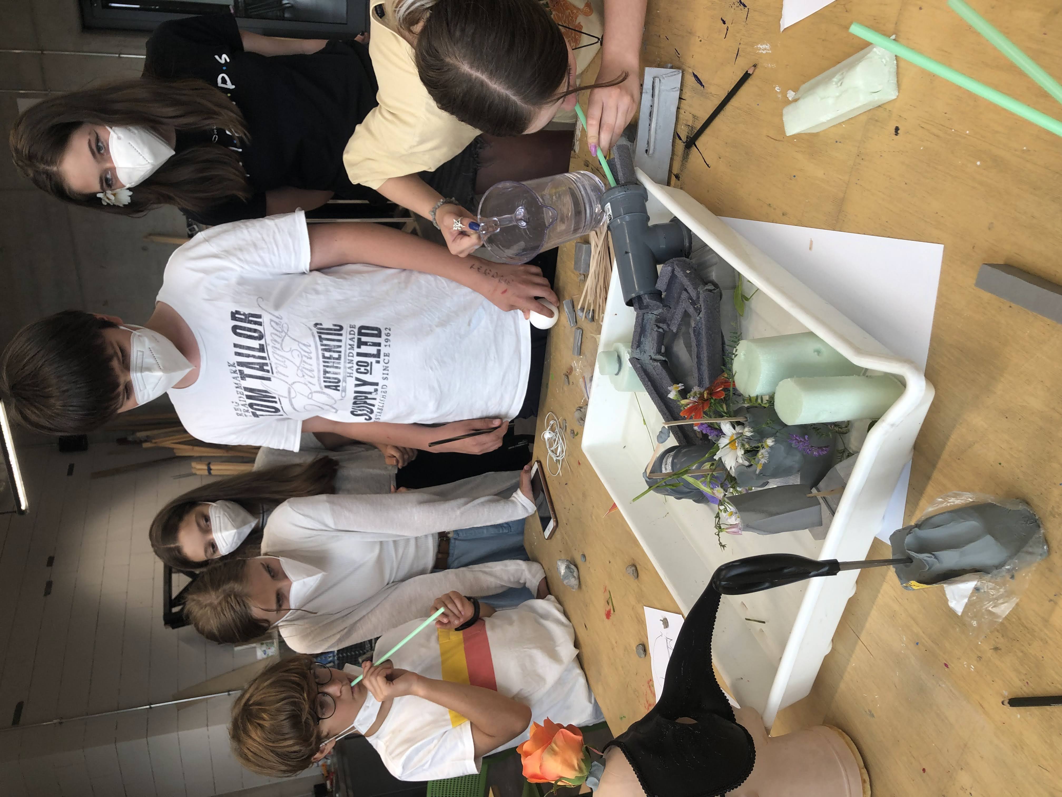 Students gathered around a worktable during Boot Camp, using materials and tools to prototype a project under time pressure.