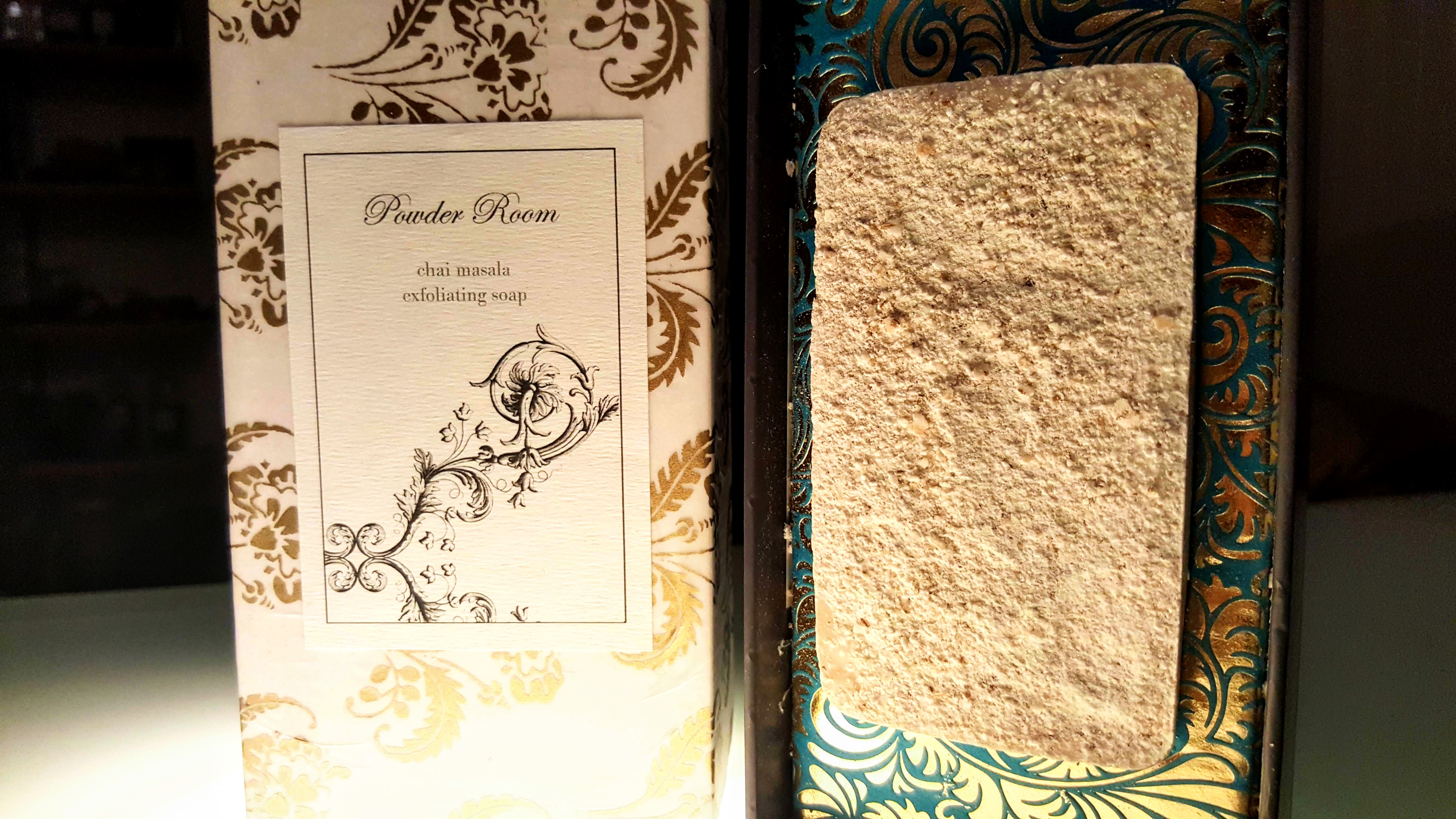 A student-made luxury soap presentation with patterned packaging, a printed Powder Room label, and the finished soap bar displayed side by side.